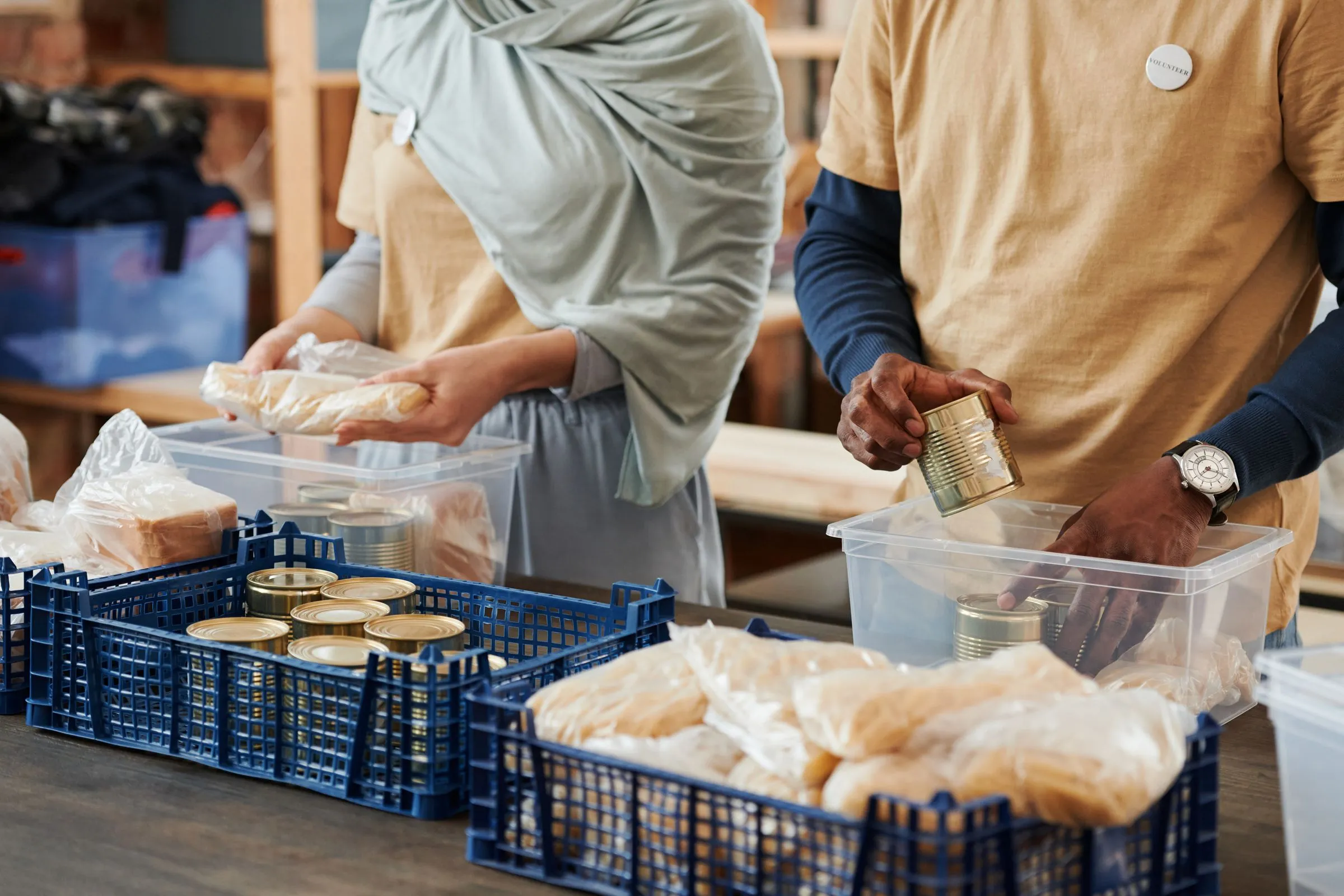 Volunteers sorting donated food into containers on a long table